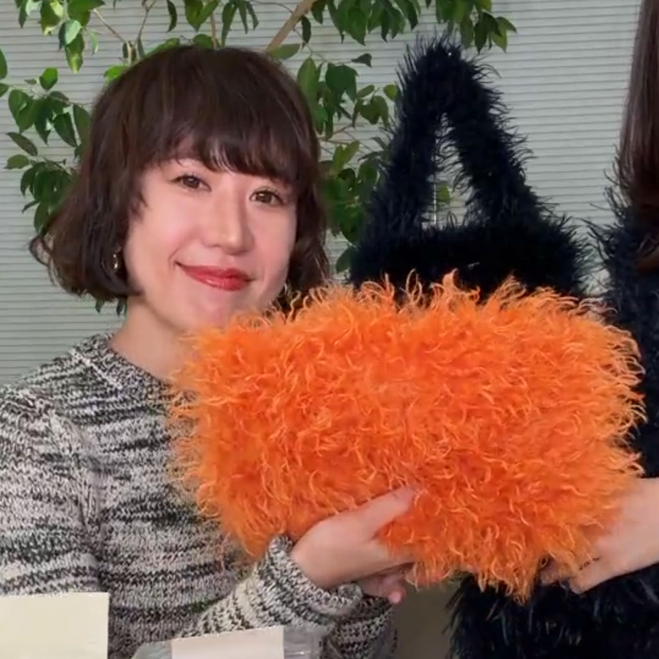 オレンジが目を引くファーポーチ